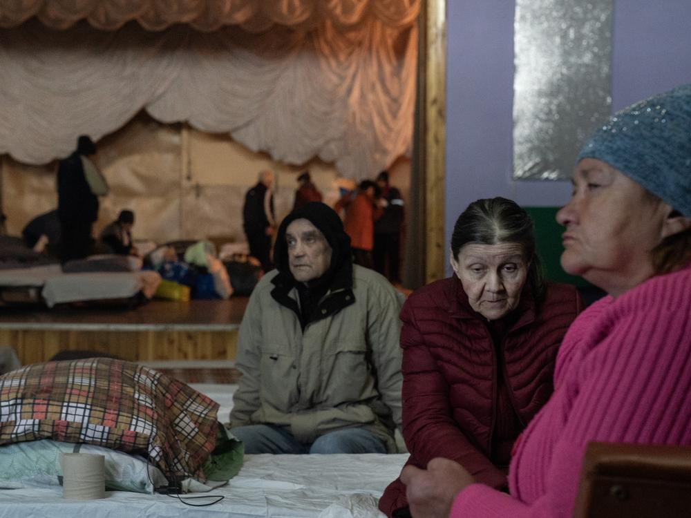 Evacuees from the mining city of Pokrovsk listen to a safety briefing at a theater turned shelter for displaced people, in Pavlohrad, Ukraine, on Oct. 19. Organizers at the facility, which offers counseling and humanitarian assistance, say that the number of people arriving has been steady with higher numbers following larger Russian attacks.