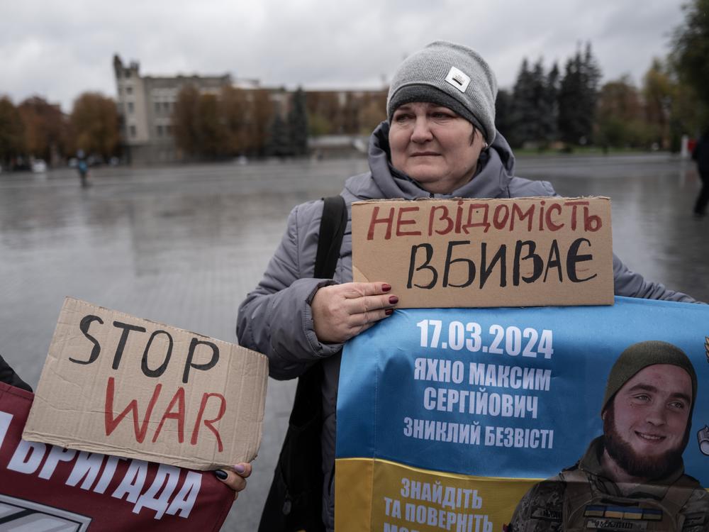 Victoria Yakhno holds a banner showing her missing son, Maksym Yakhno, during a demonstration on the main square in Pavlohrad, Ukraine, on Oct. 19. The relatives of missing and imprisoned soldiers line streets across Ukraine, usually on weekends, to draw attention to their missing loved ones. Pavlohrad is part of a chain of mining centers along a highway stretching east from the Donbas region.