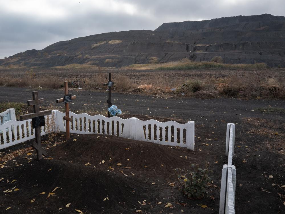A slag heap from a nearby coal mine is seen from a cemetery at the edge of the mining town of Dobropillya, Ukraine, on Oct. 17. The front line is nearby as Russian forces advance on Pokrovsk an important coal mining center a little over 8 miles southeast of Dobropillya.