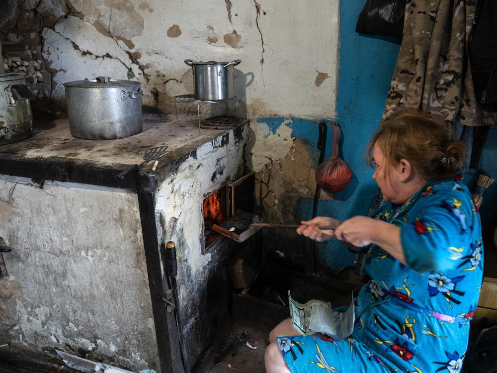 Daria Kuznetsova burns coal in her kitchen stove in Dobropillya, Ukraine, on Oct. 17.