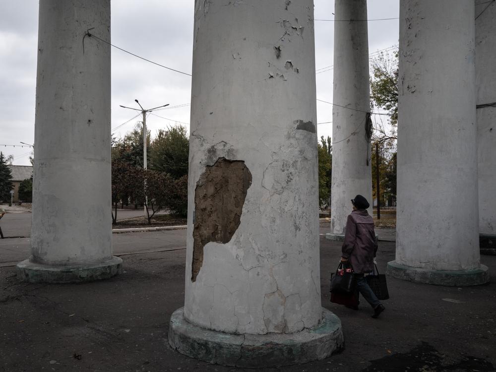 A woman exits a building after receiving humanitarian aid in Dobropillya, Ukraine, on Oct. 17. Dobropillya frequently comes under aerial attack from Russian missiles and drones.