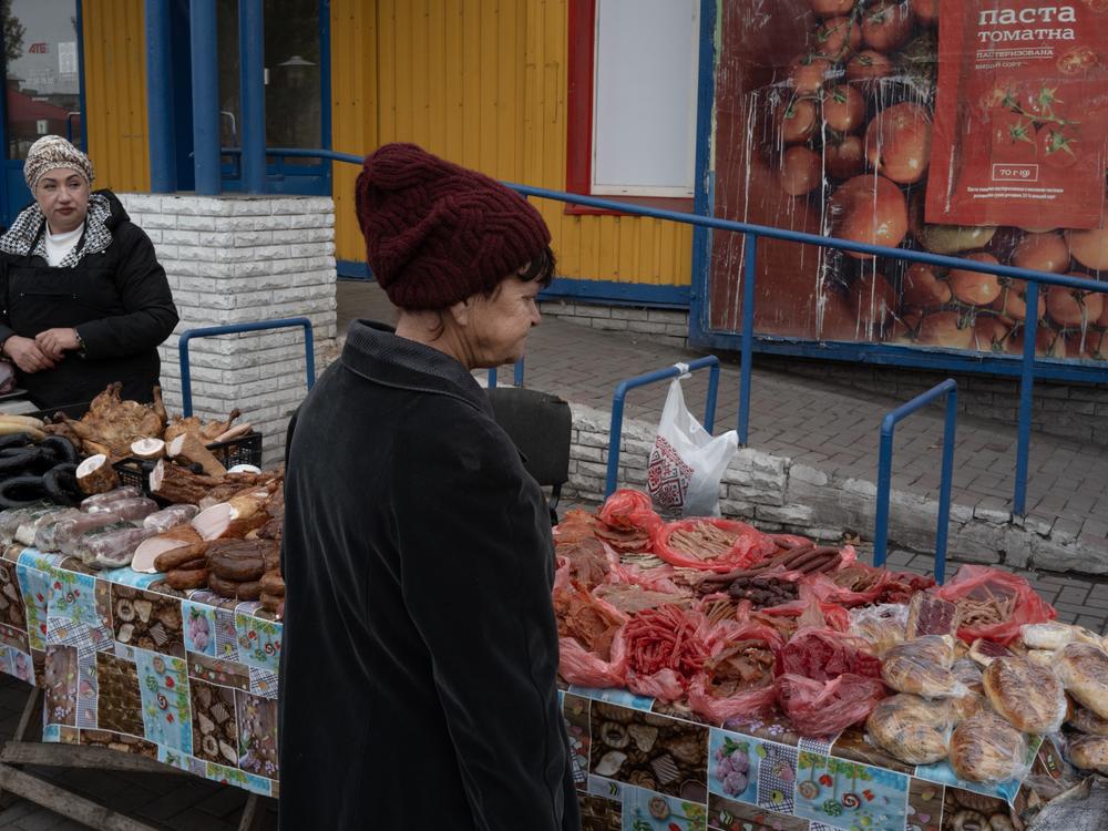 Lilia Lymanska (right) sells home-cured meats at her market stall in Dobropillya, Ukraine, on Oct. 17. Lymanska lives in nearby Pokrovsk, a coal mining center that is very close to the front line and is under frequent Russian artillery barrages and aerial attacks. She says it is impossible to sell her goods there and it has become increasingly dangerous. Dobropillya is also frequently coming under attack by Russian missiles, drones and rockets.
