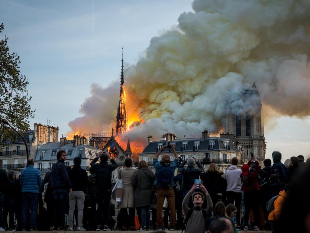 People watch the landmark Notre Dame Cathedral burning in central Paris on April 15, 2019.