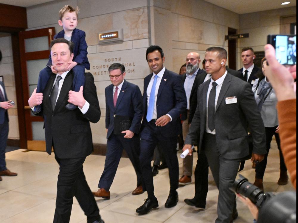 Tesla CEO Elon Musk (left), co-chair of the newly created Department of Government Efficiency (DOGE), carries his son 