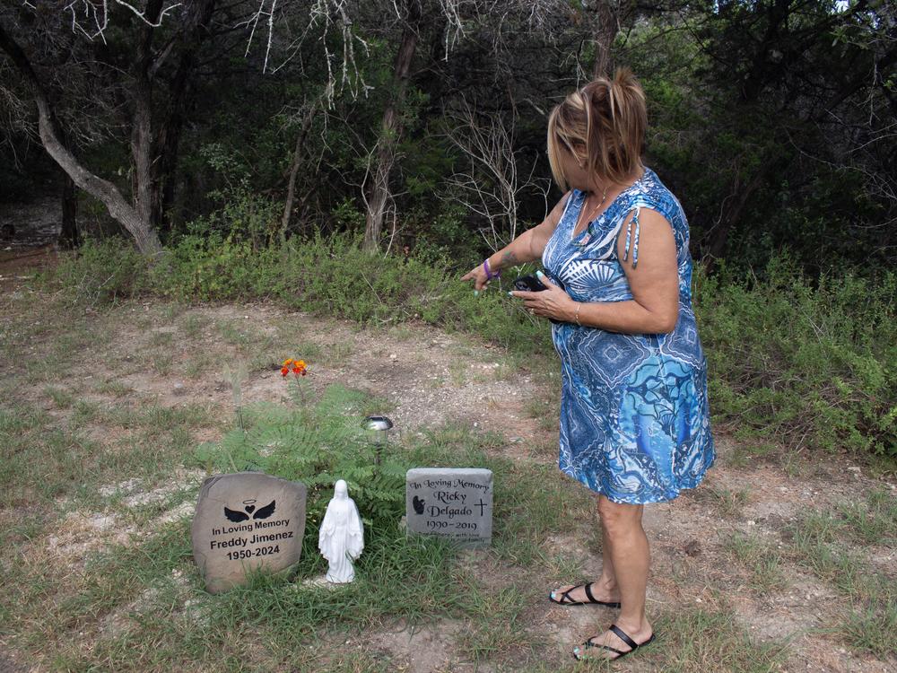 Margo Jimenez points out a memorial to her late husband, Fred Jimenez, in her yard – a stone with his name engraved on it. Next to it stands another stone, in remembrance of her son who died in a car accident.