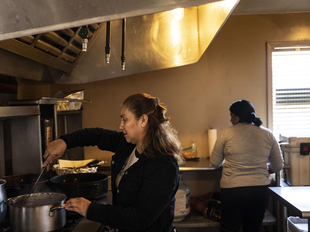 Sofía Hernandez tends to the burners in the kitchen of her business, Maria's Mercado.