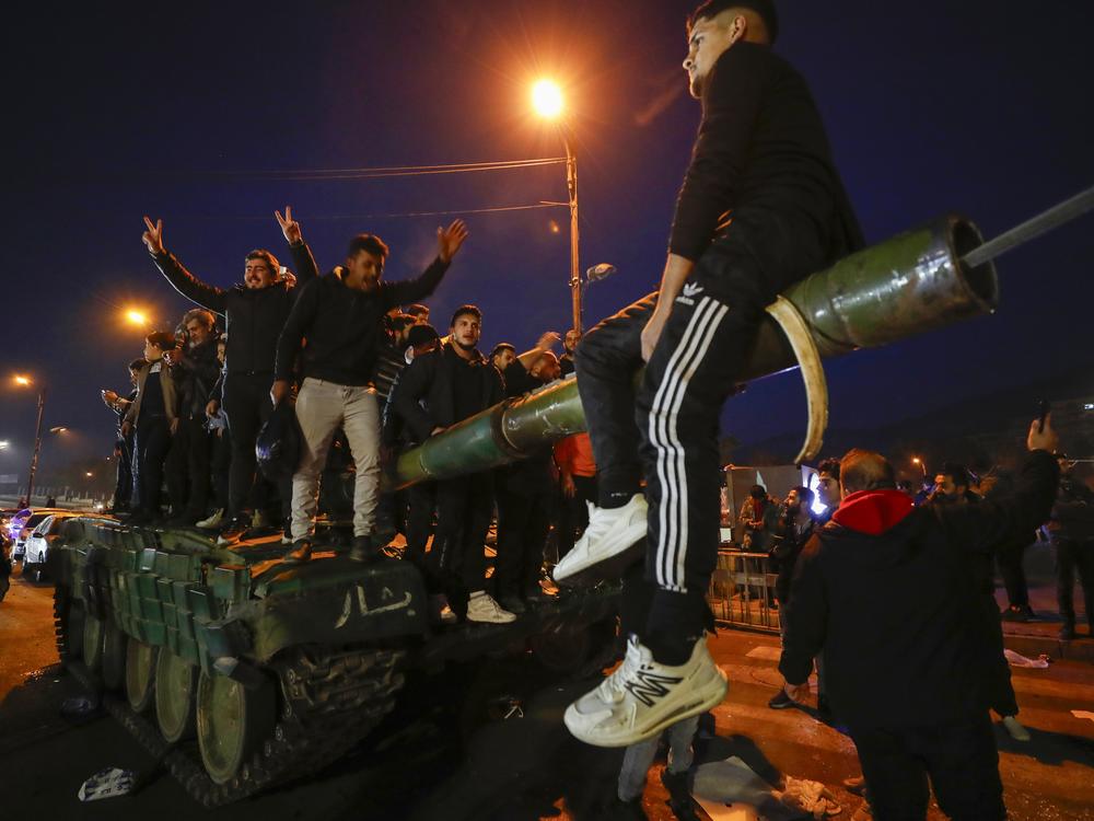 Syrians celebrate the arrival of opposition fighters in Damascus, Syria, on Sunday.