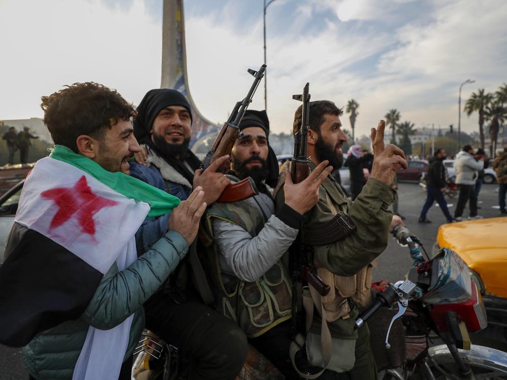 Syrian opposition fighters celebrate after the Syrian government collapsed in Damascus, Syria.