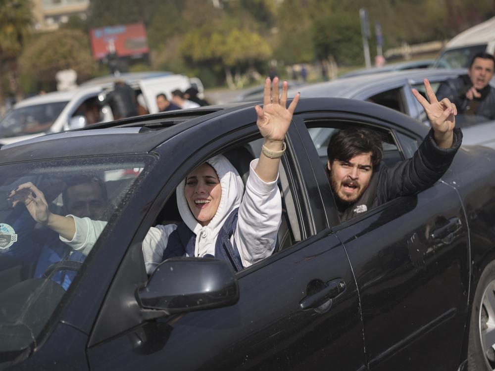 Residents celebrate the fall of the capital Damascus to opposition forces, in Homs, Syria.