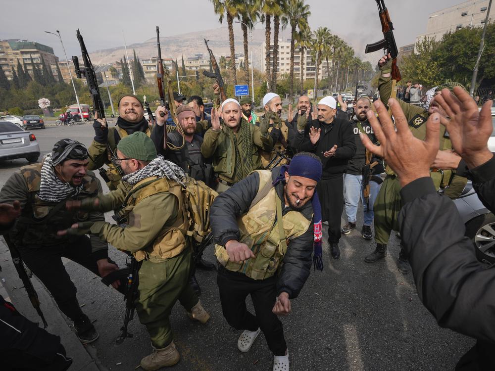 Opposition fighters celebrate in Damascus, Syria.