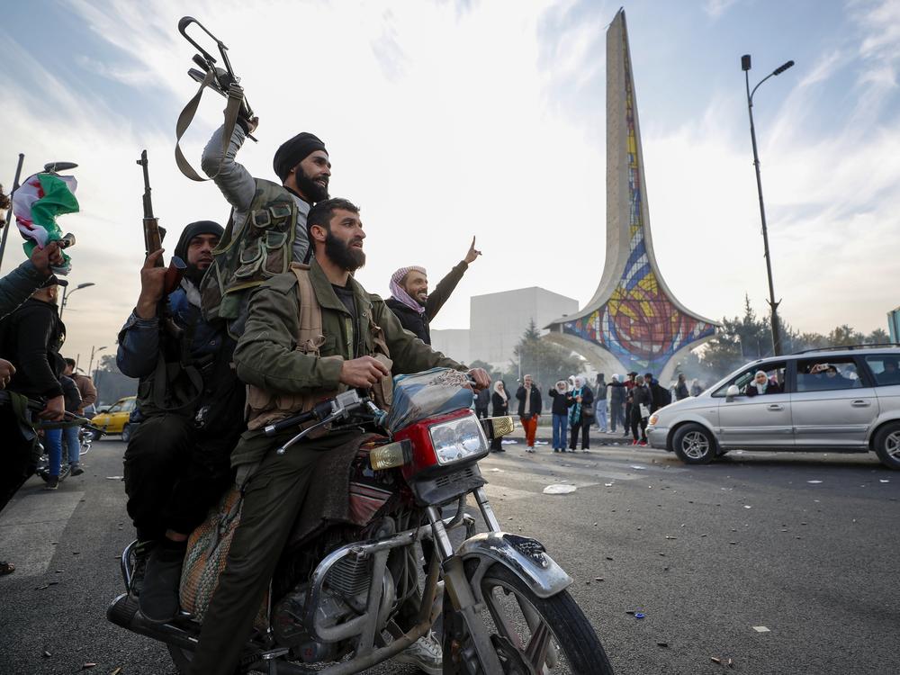 Syrian opposition fighters celebrate the fall of the Syrian government, in Damascus, Syria on December 8, 2024.