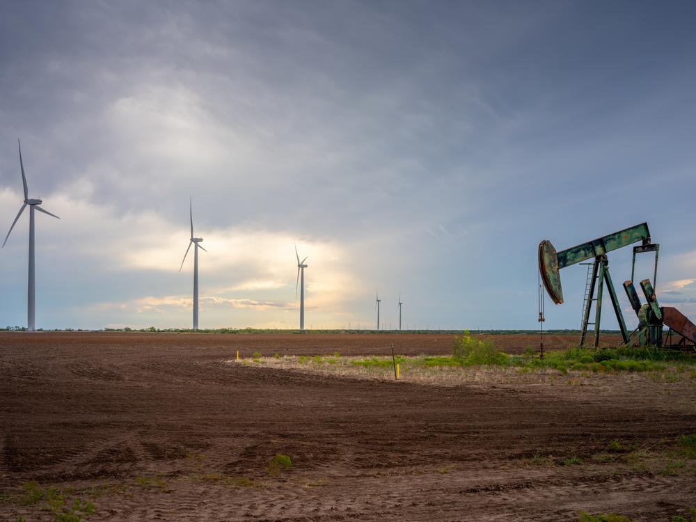 An oil pumpjack is seen near a field of wind turbines in October 2023 in Nolan, Texas. The U.S. oil industry is headed towards a record-breaking year; renewable energy has also set several records this year. Prominent Republicans, including several in President-elect Donald Trump's circle, are talking about an 