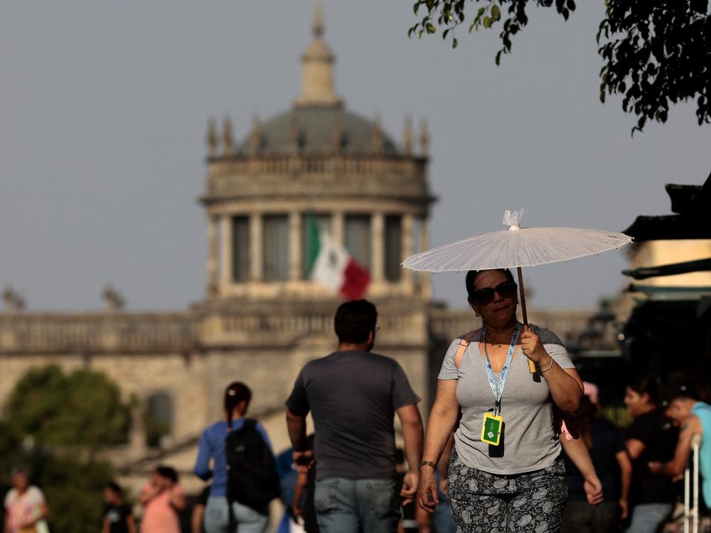 People protect themselves from the sun during a heat wave in Guadalajara, Mexico, in 2024. Temperatures topped 110 degrees Fahrenheit across many parts of the country during the heat wave. A new study finds that young people are disproportionately at risk from extreme heat in the country.
