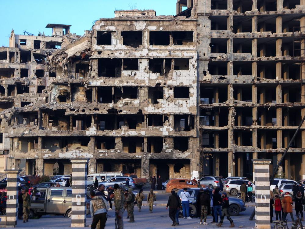 Syrian rebel fighters and civilians gather in the central city of Homs, after rebel forces entered Syria's third city overnight.
