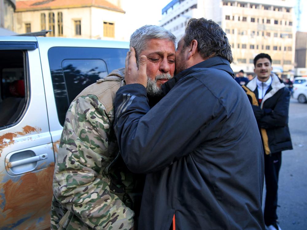 A man kisses a Syrian rebel fighter who returned to the central city of Homs, after being in exile for 12 years after rebel forces entered Syria's third city overnight.