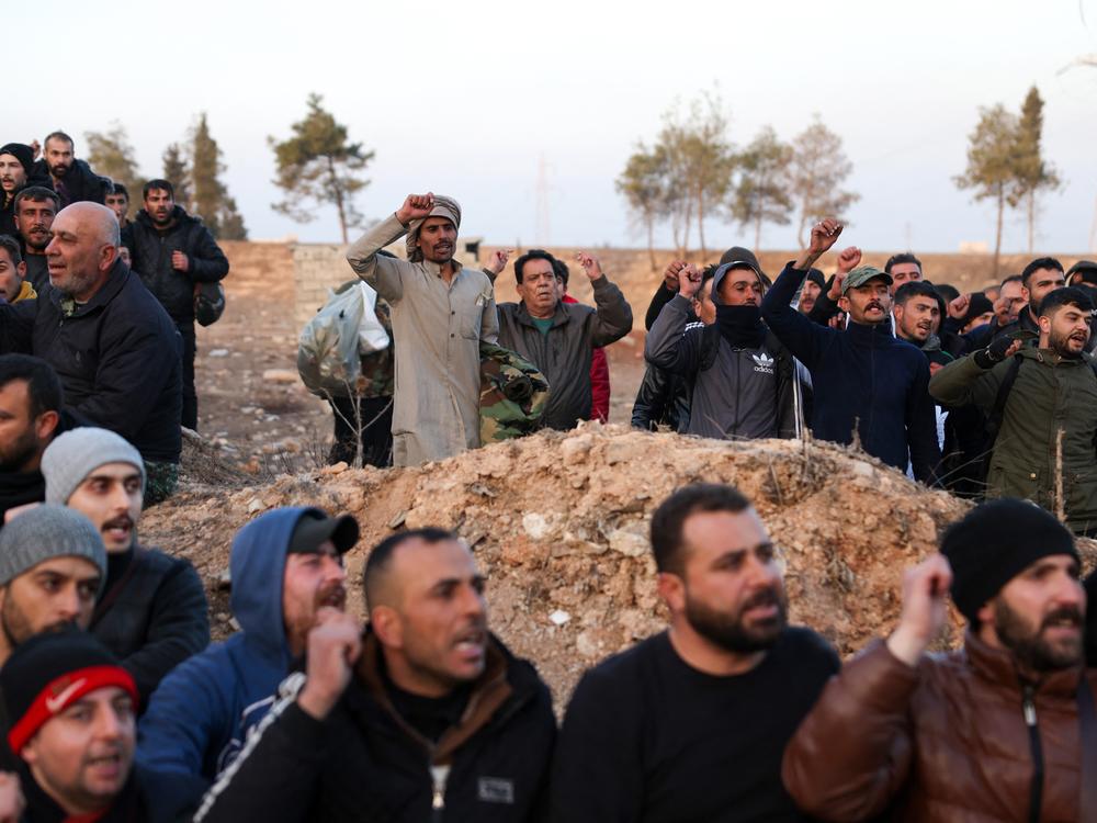 Detained Syrian pro-government soldiers chant slogans outside the central city of Homs, after surrendering when rebel forces entered Syria's third city overnight.