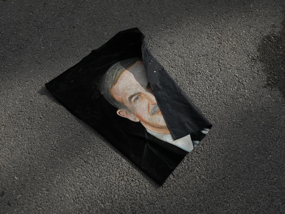 A portrait of Hafez al-Assad, father of Bashar al-Assad, is seen discarded, in Umayyad Square in Damascus, Syria.
