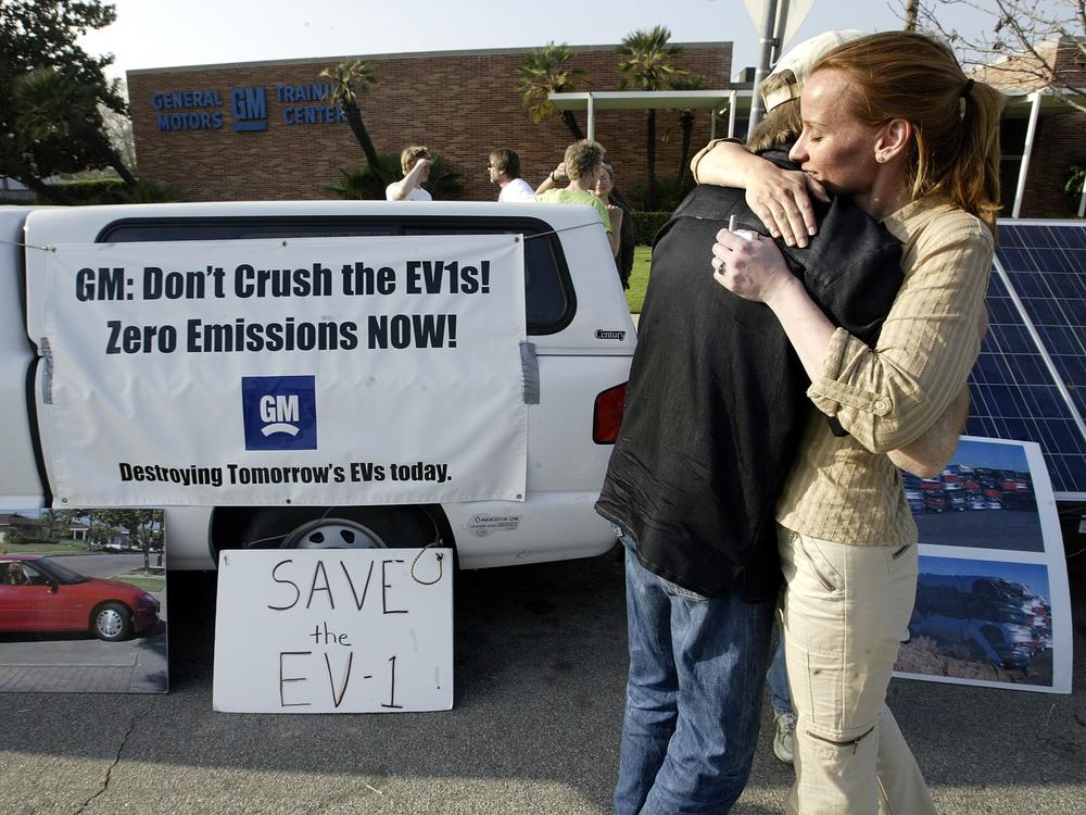 Chelsea Sexton hugs Paul Scott during a vigil held outside the General Motors Training Center in Burbank, Calif., protesting GM's plans to crush its EV1 electric vehicles located in the facility's parking lot.