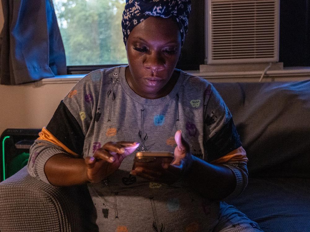 Kiki Polk checks her electric bill on her phone to see if the credit from the Clean Power Prescription has been applied to her account.