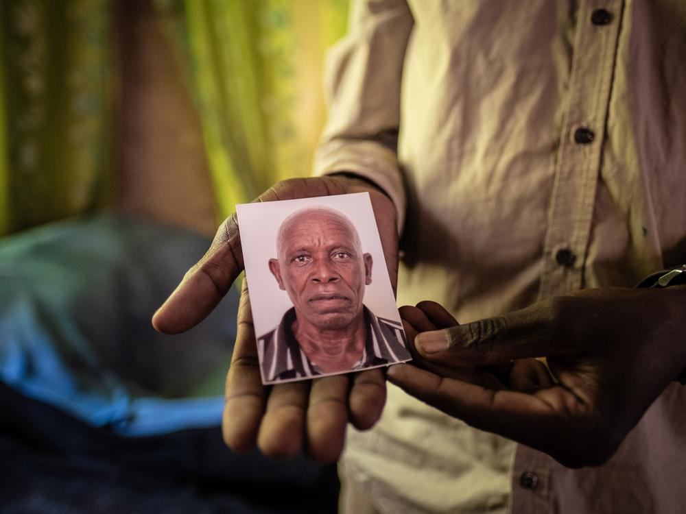 Luka Chiyesu, 39, displays a photo of his father, Luka Makongo Chiyesu, 91, who was killed by an elephant in Livingstone, Zambia, in August 2024.