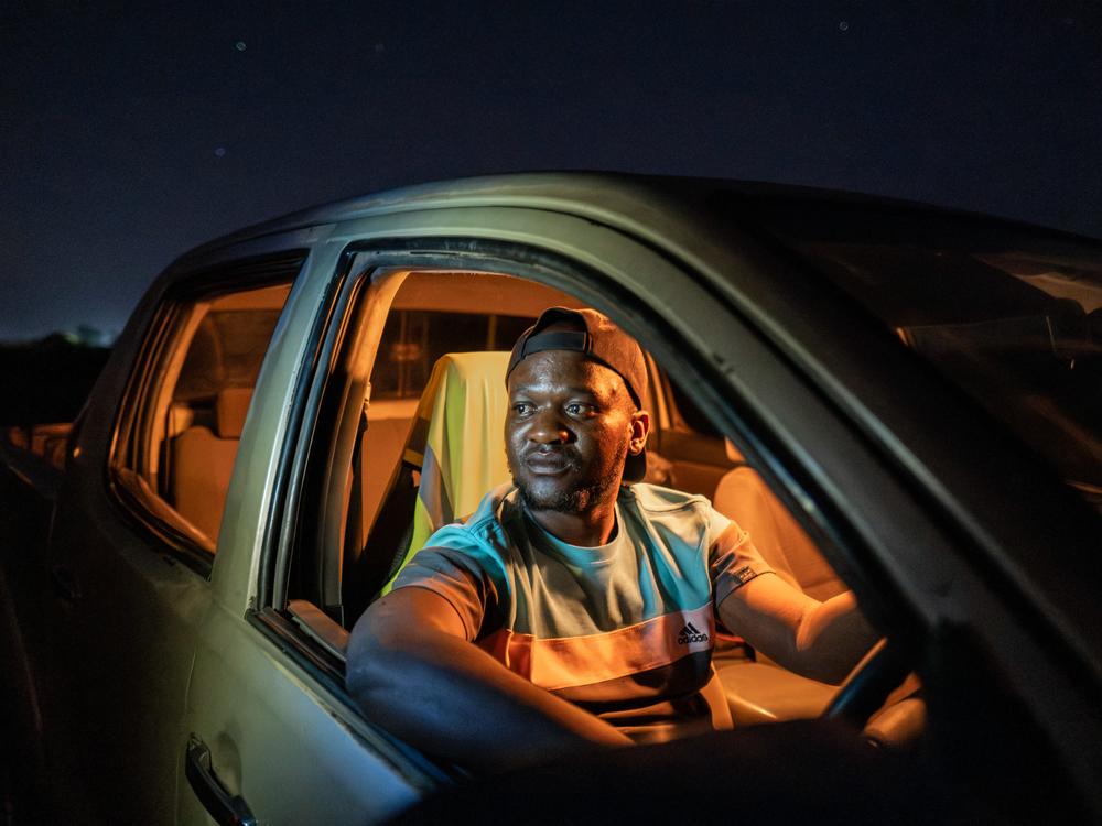 Chamunolwa Jimayi, 29, a driver for the Elephant Response Team, photographed in his vehicle at night in Livingstone, Zambia. 