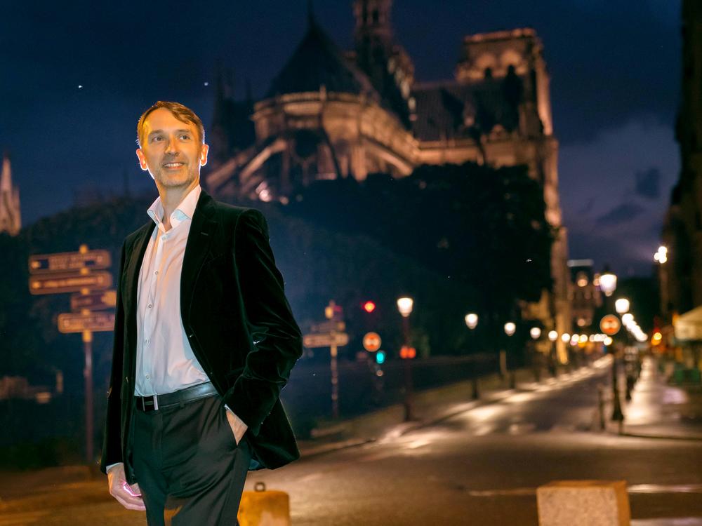 Olivier Latry, standing near Notre Dame in Paris, is the cathedral's longest-serving organist.  He'll take part on the reopening ceremonies, beginning Dec. 7.