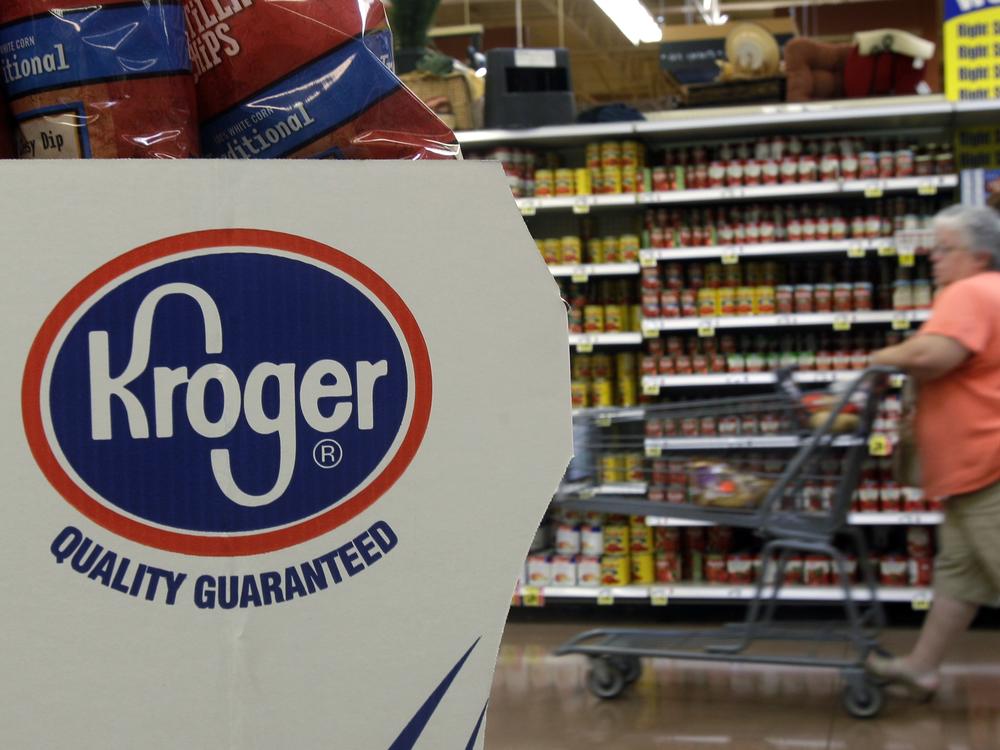 A shopper pushes a cart through a Kroger supermarket in Newport, Ky.