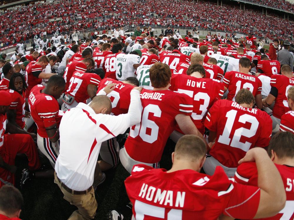 The Ohio State football team prays before a game in 2007.