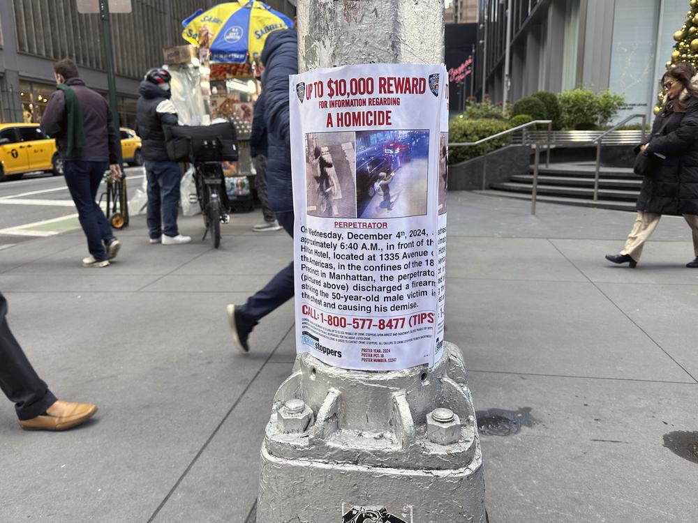 A reward poster hangs on a light pole outside the New York Hilton Midtown Hotel in New York last week. The NYPD offered up to $10,000 for tips leading to the shooting suspect's arrest, while the FBI offered up to $50,000.
