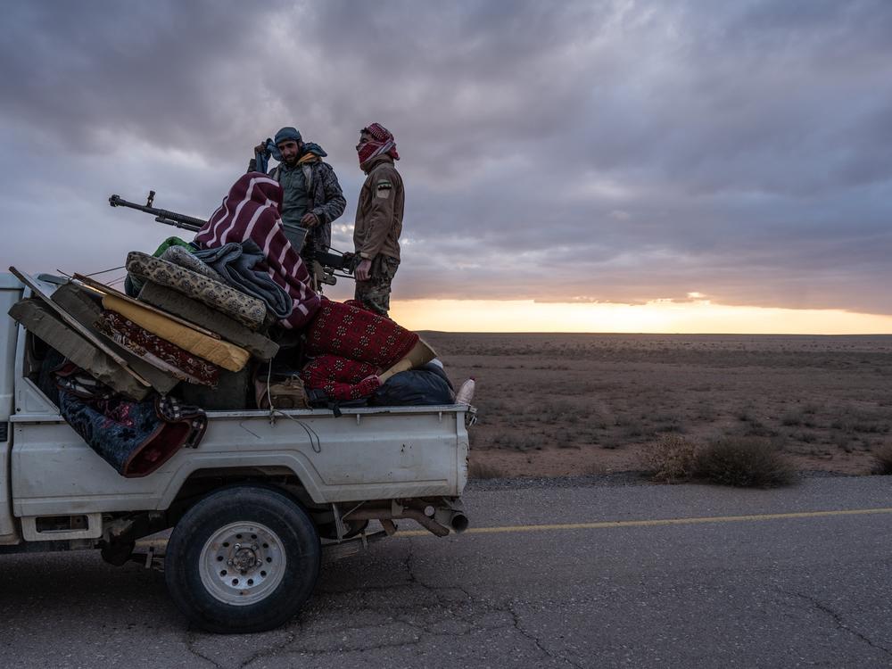 Free Syrian Army members escort the convoy taking Timmerman to be handed over to U.S. forces on Friday.