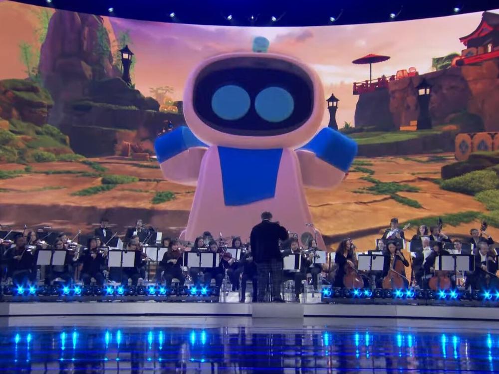 The titular Astro Bot looms over an orchestra playing a medley from the soundtracks to the six Game of the Year nominees.