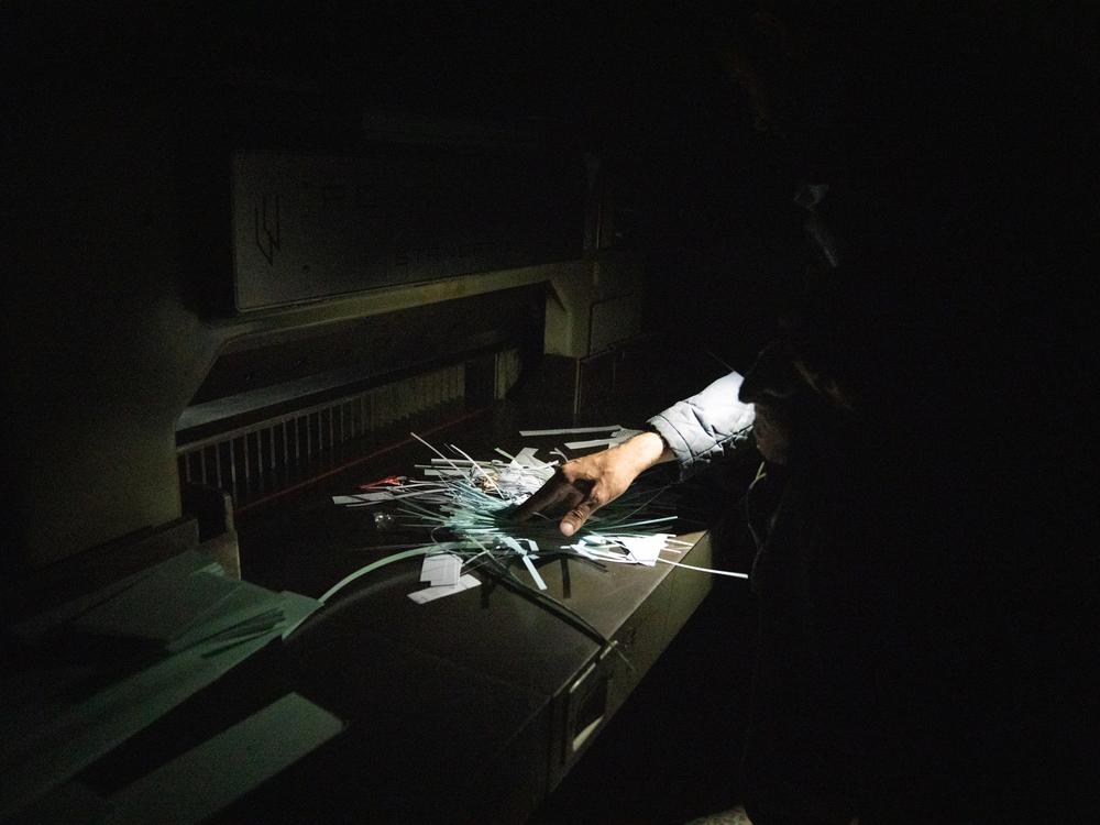 Moustafa sifts through shredded documents he finds in the former Air Force Intelligence building in Damascus.