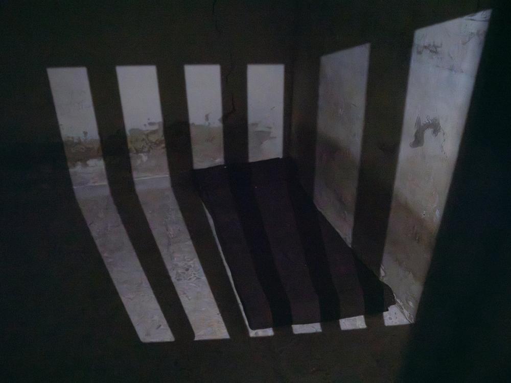 A single mattress lies in a cement cell where Moustafa says a lone prisoner was recently discovered.