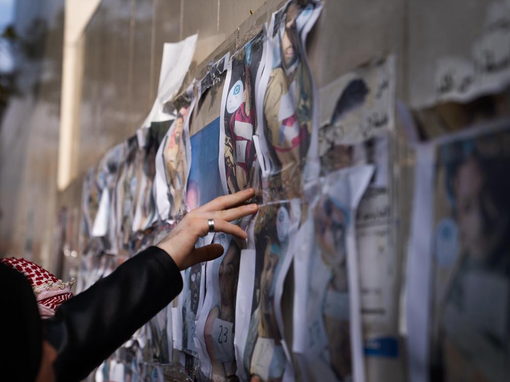 Posters showing photos of dead bodies that had been tortured hand on a wall in Damascus, people go to look at them to try and identify lost family members and friends.