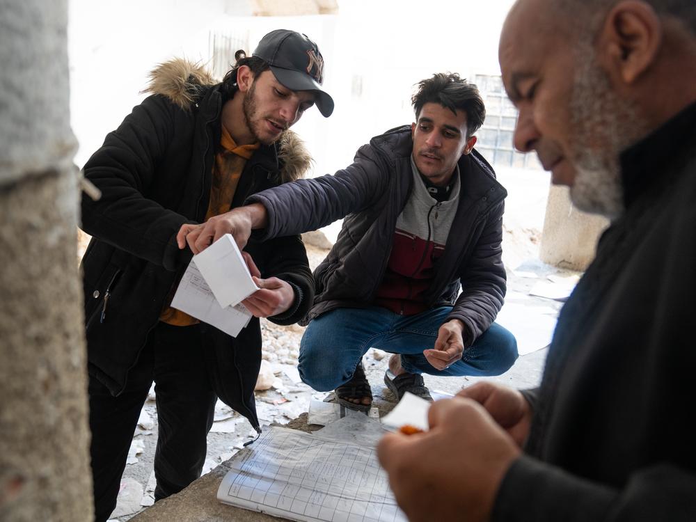 People search through handwritten notes and log books that are strewn around Sednaya prison just North of Damascus. Many are still looking for loved ones who were detained by the Assad regime.