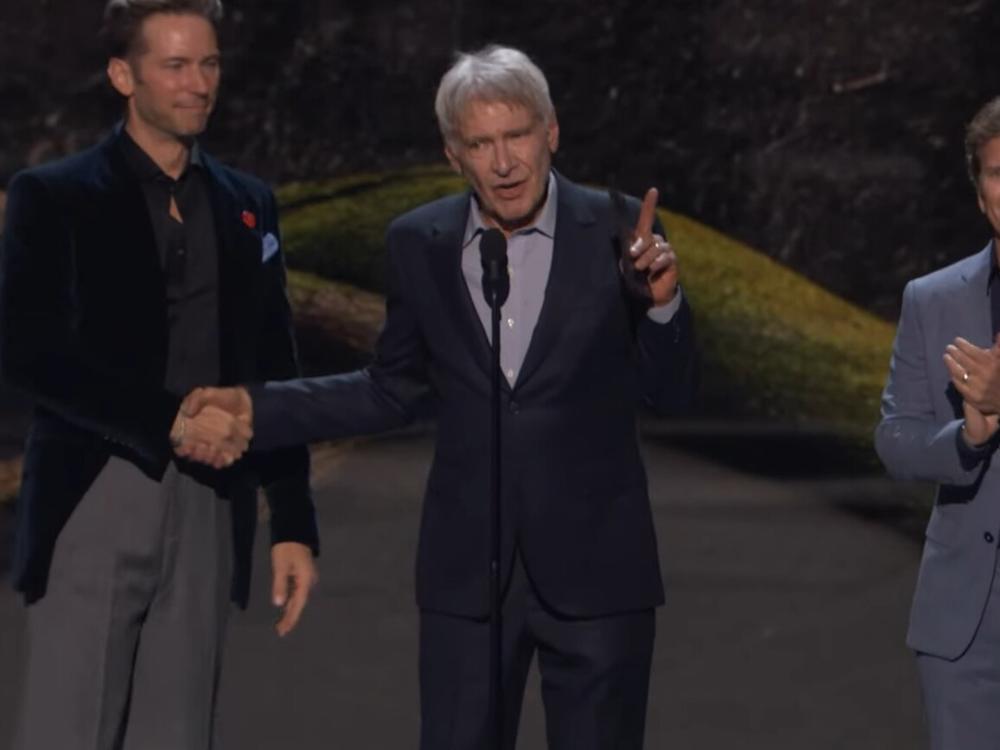 Harrison Ford shakes hands with Troy Baker at The 2024 Game Awards as Bethesda's Todd Howard looks on. 