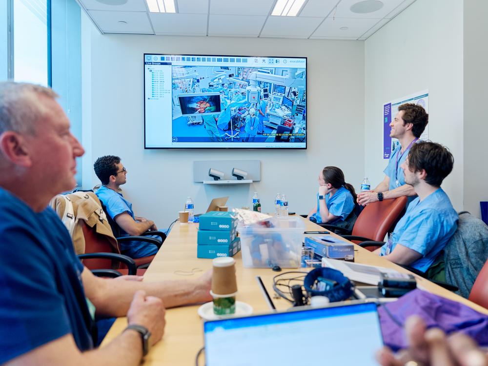 David Ayers (foreground left), chief science officers at Revivicor, of Blacksburg, Va., watches a surgical team transplant a kidney from one of the company's genetically modified cloned pigs into a patient.