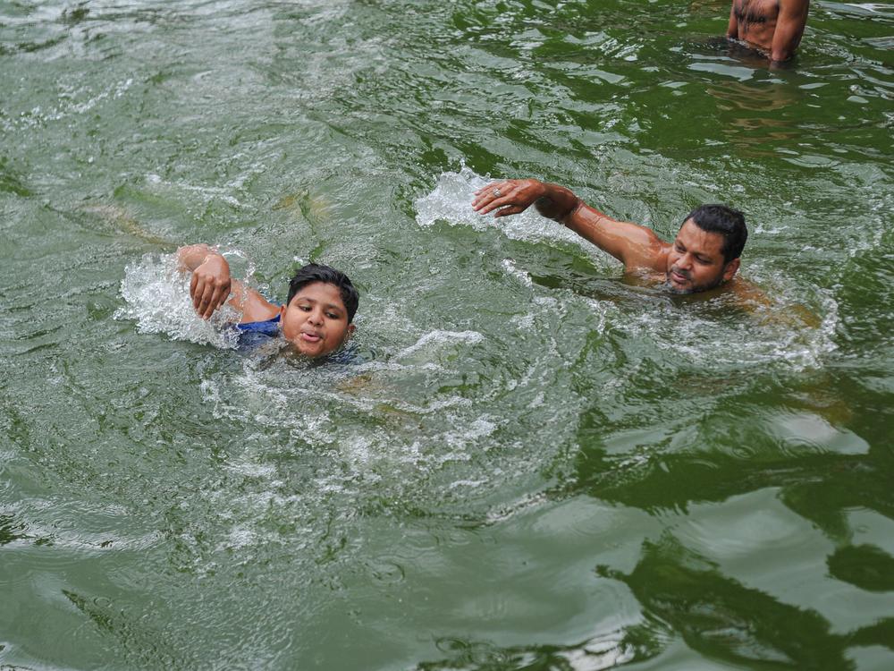 A father teaches his child to swim in a pond in Sylhet, Bangladesh. Drowning is a leading causes of death globally for children, according to the first ever report on drowning as a public health issue issued by the World Health Organization.