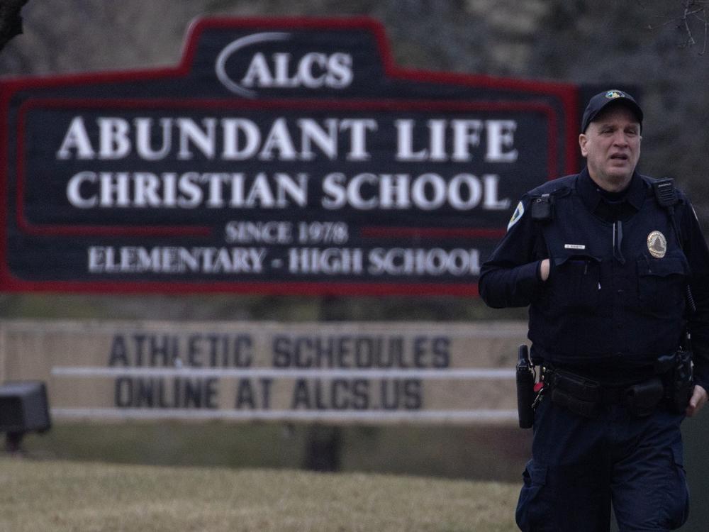 A police officer stands guard in front of Abundant Life Christian School on Monday in Madison, Wis.