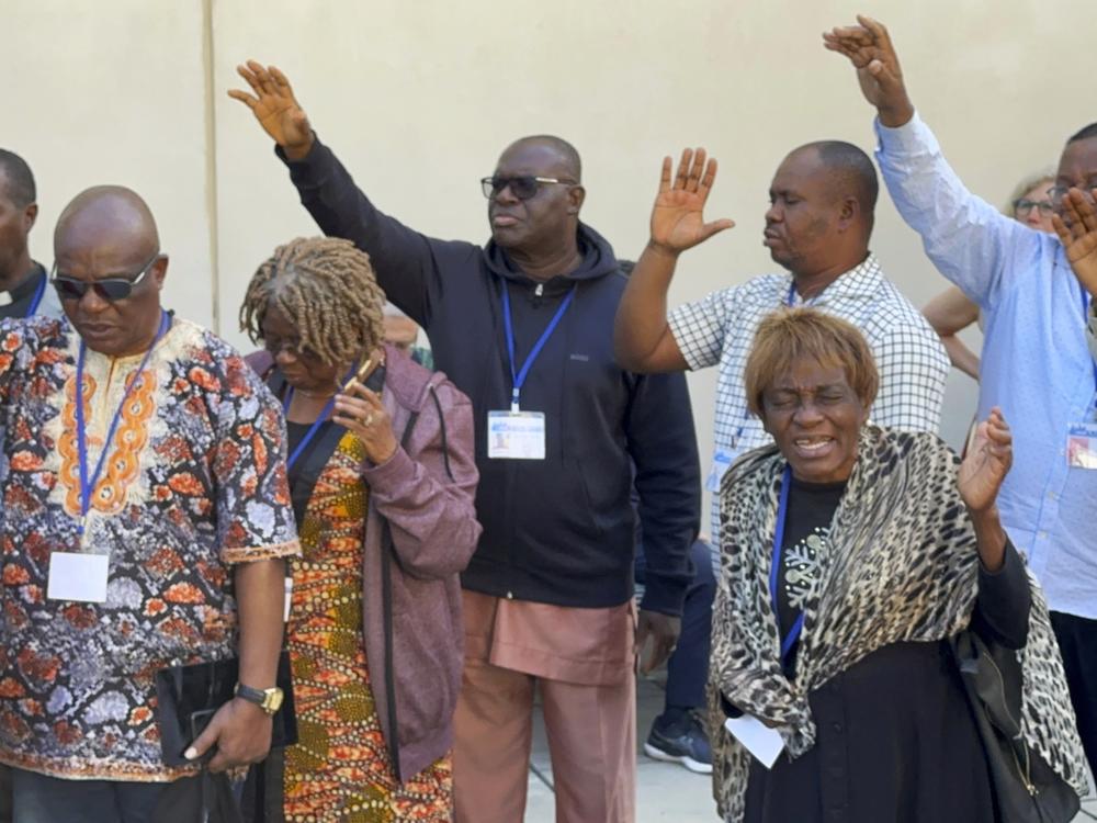 African delegates to the General Conference of the United Methodist Church pray outside the Charlotte Convention Center, in Charlotte, N.C., on May 2, 2024.