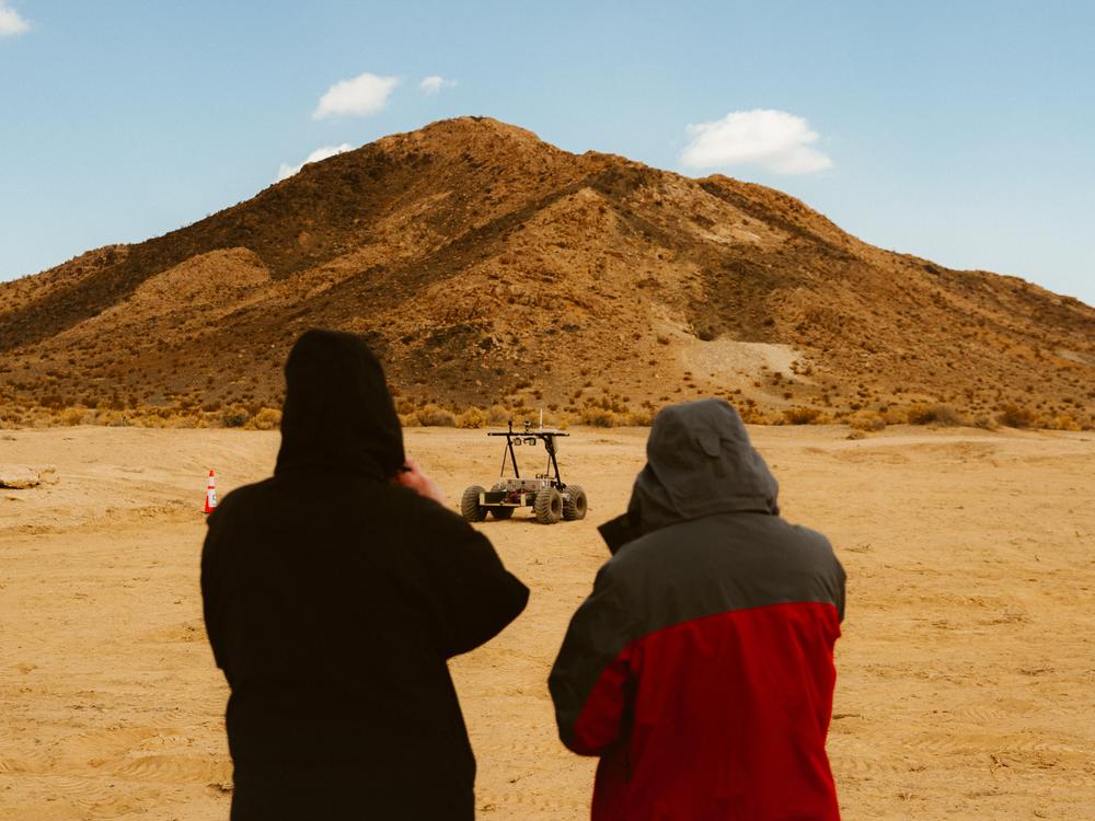 Two people admiring the Helelani rover.