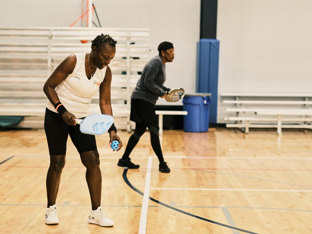Pickleball player Debra Wells-Lynn, 70, prepares to serve during a match at the Florida Senior Games. Wells-Lynn is a former tennis player who picked up pickleball when she moved to Florida.