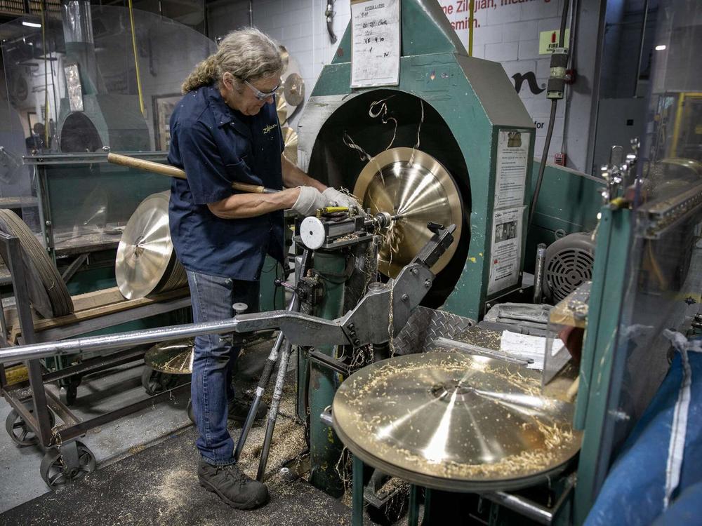 Cymbalsmith Peter Nelson works on a cymbal on a lathe at the Zildjian cymbal factory in Norwell, Mass. (Robin Lubbock/WBUR)