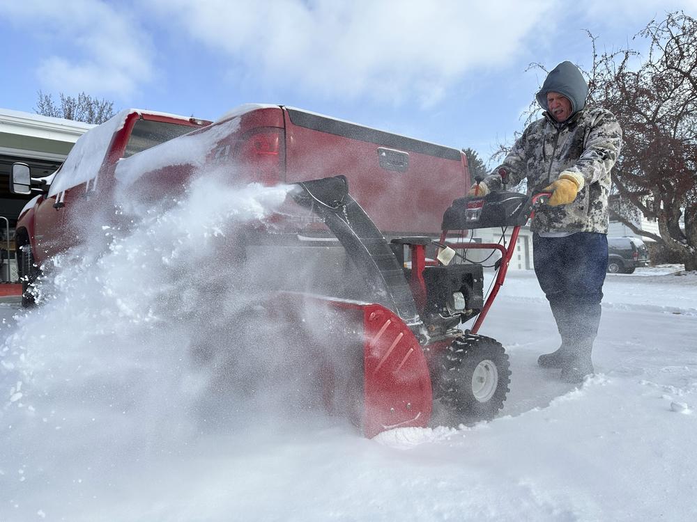 Jim Thom clears his driveway of snow with a snowblower on Dec. 19, 2024, in Bismarck, N.D.
