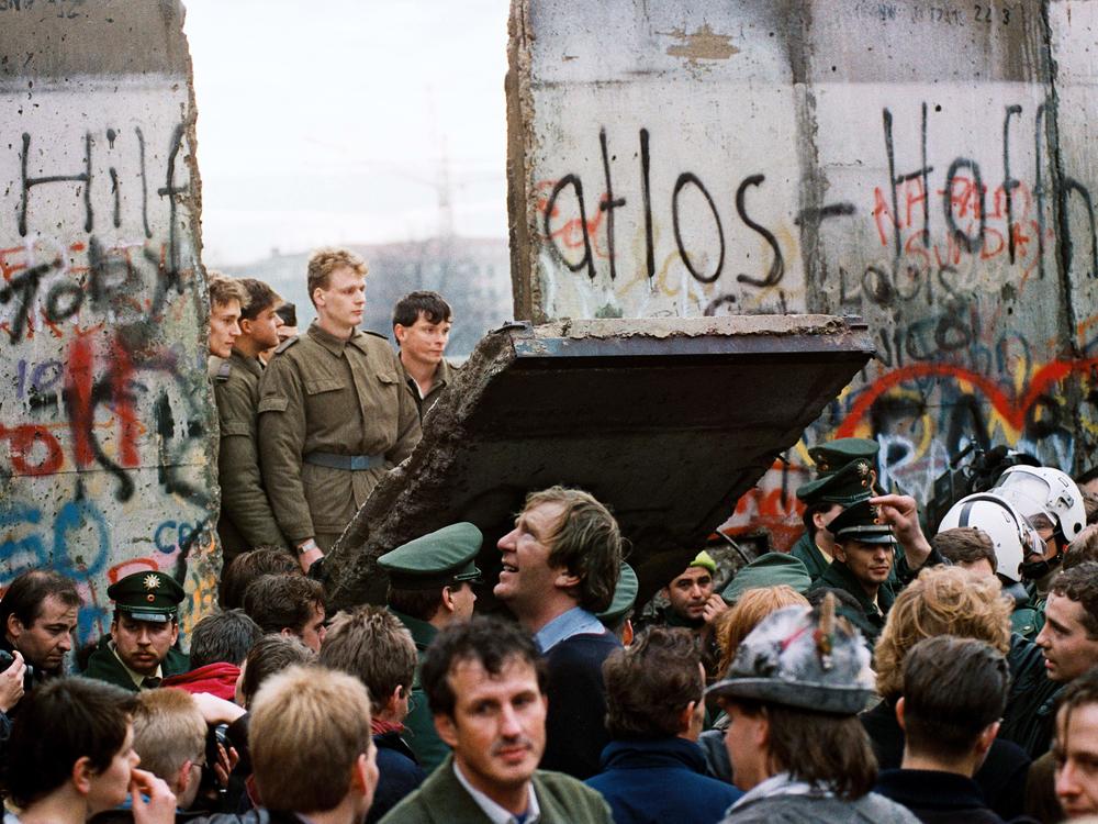 West Berliners crowd in front of the Berlin Wall early on Nov. 11, 1989, as they watch East German border guards demolish a section of the wall to open a new crossing point between East and West Berlin near the Potsdamer Platz public square.