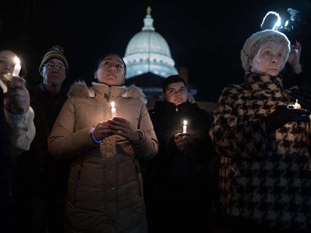 People attend a vigil on the grounds of the Wisconsin State Capitol building to mourn the victims of the shooting at Abundant Life Christian School in Madison, Wis.