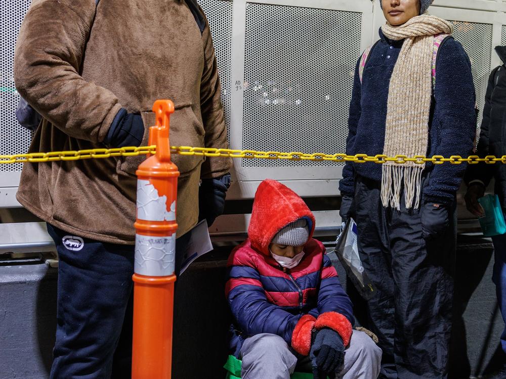 Hondurans David Melgar, 28, his wife Gabriela Maradiaga, 26 and their son Tailer Melgar, 8, wait atop the Paso del Norte Bridge to be allowed into the United States for their CBP One appointment.