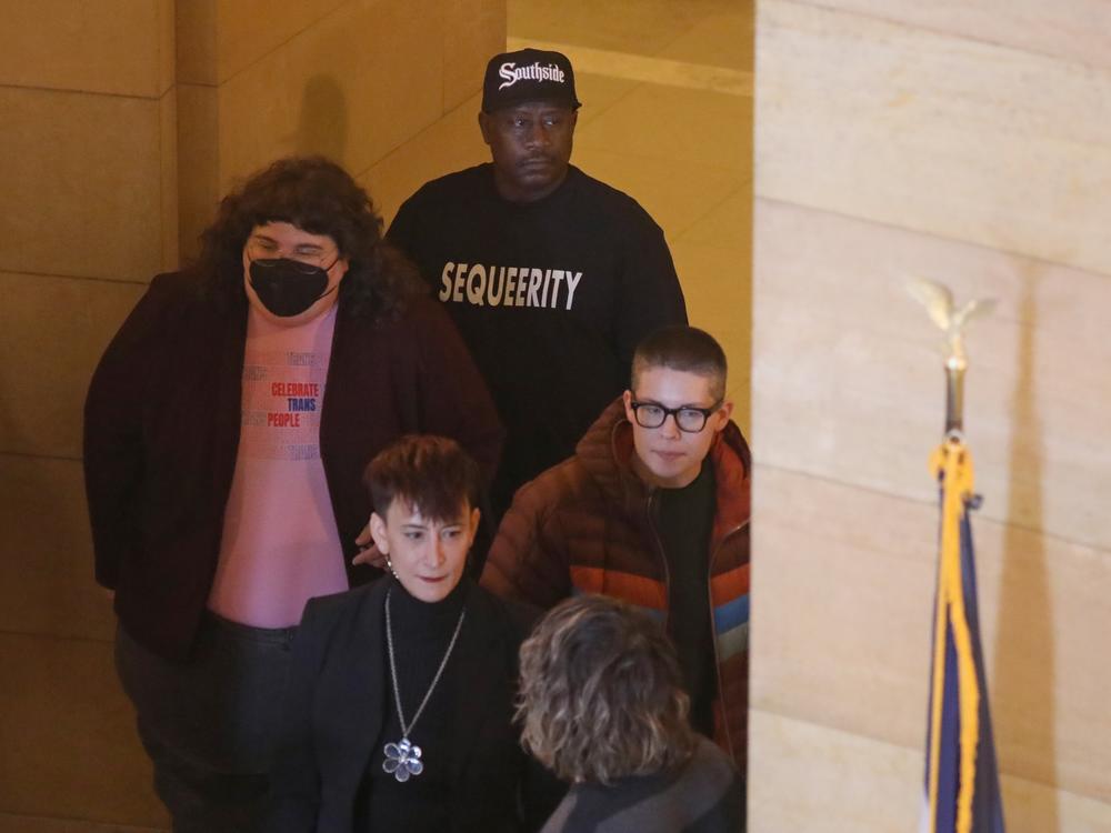 Kim Austell watches over a press conference as the group Sequeerity monitors for any confrontations at the Minnesota State Capitol in Saint Paul, Minn., Dec. 3.