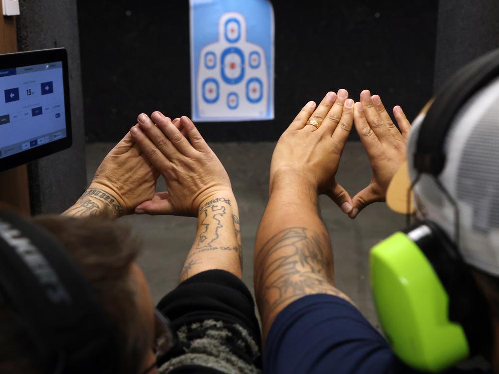 Founder of Sequeerity, Kimmy Hull teaches Jayce, a Minneapolis-area resident, about handling firearms and safety at a gun range outside Minneapolis, Minn., Dec. 3.