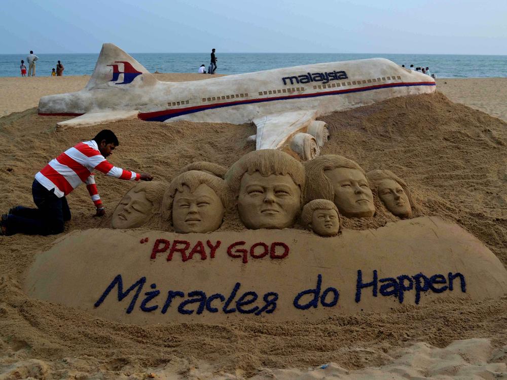 Indian sand artist Sudersan Pattnaik gives final touches on a sand sculpture with a message of prayers for the missing Malaysian Airlines Flight MH370, which vanished from radar early on March 8 somewhere at sea between Malaysia and Vietnam, at Puri Beach, on March 9, 2014.